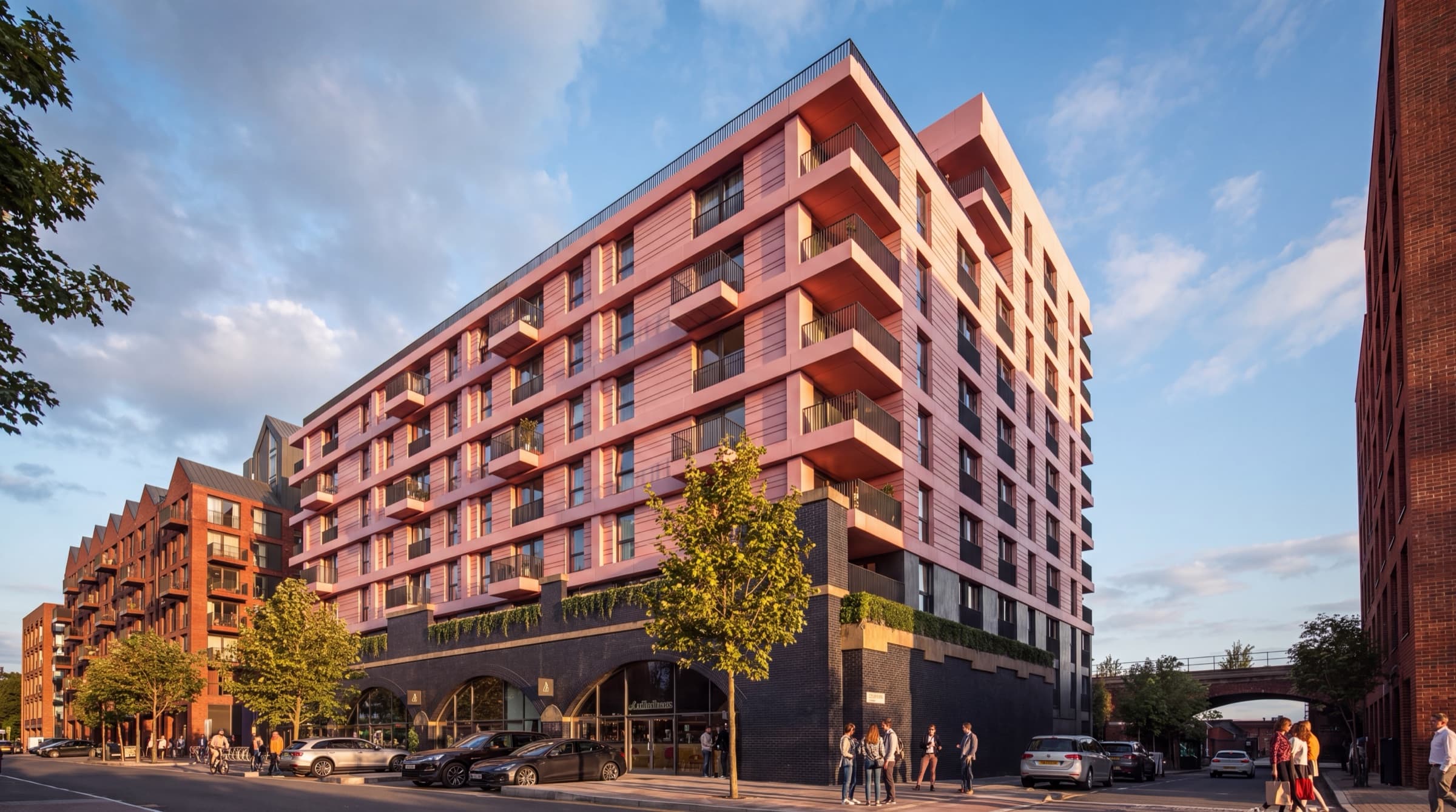 Street view of the terracotta-clad block with ground-floor cafés