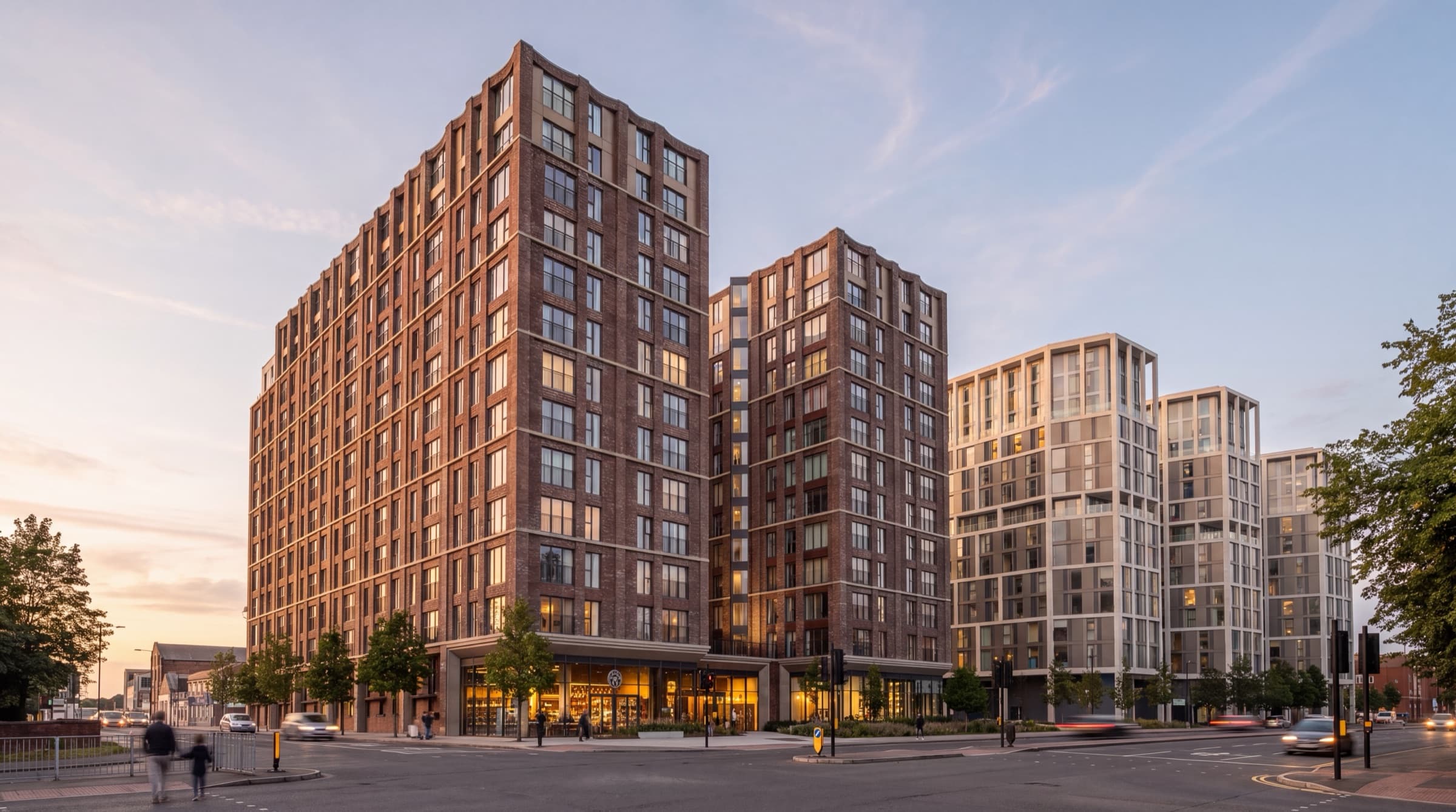 The development's brick and stone towers at dusk from street level